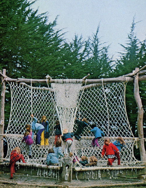 A pile of kids climb over a knotted rope playground