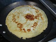 A crêpe pancake cooking in a pan