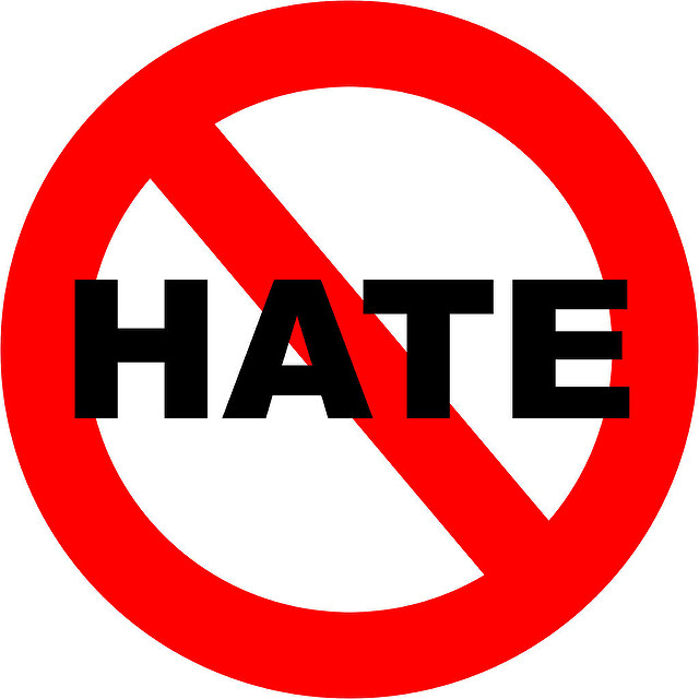 Graphic of the word HATE in black text on a white background, with a red circle and a diagonal overlay symbolising NO, thus together NO HATE