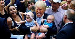 Trump holding two babies, one crying, and making a scrunched-up crying face at an appearance in Colorado Springs
