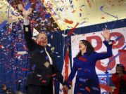 Doug and Louise Jones stand on stage amid a cloud of confetti after Doug's victory in the Alabama Senate special election Dec. 12