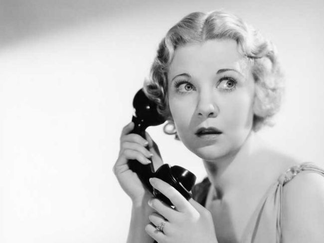 Black-and-white, 1950s-style image of a scared, blonde, white woman on the phone