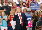 Photo of Trump at a rally in Arizona, smiling and holding a hand to his ear to better here the screams of his supporters